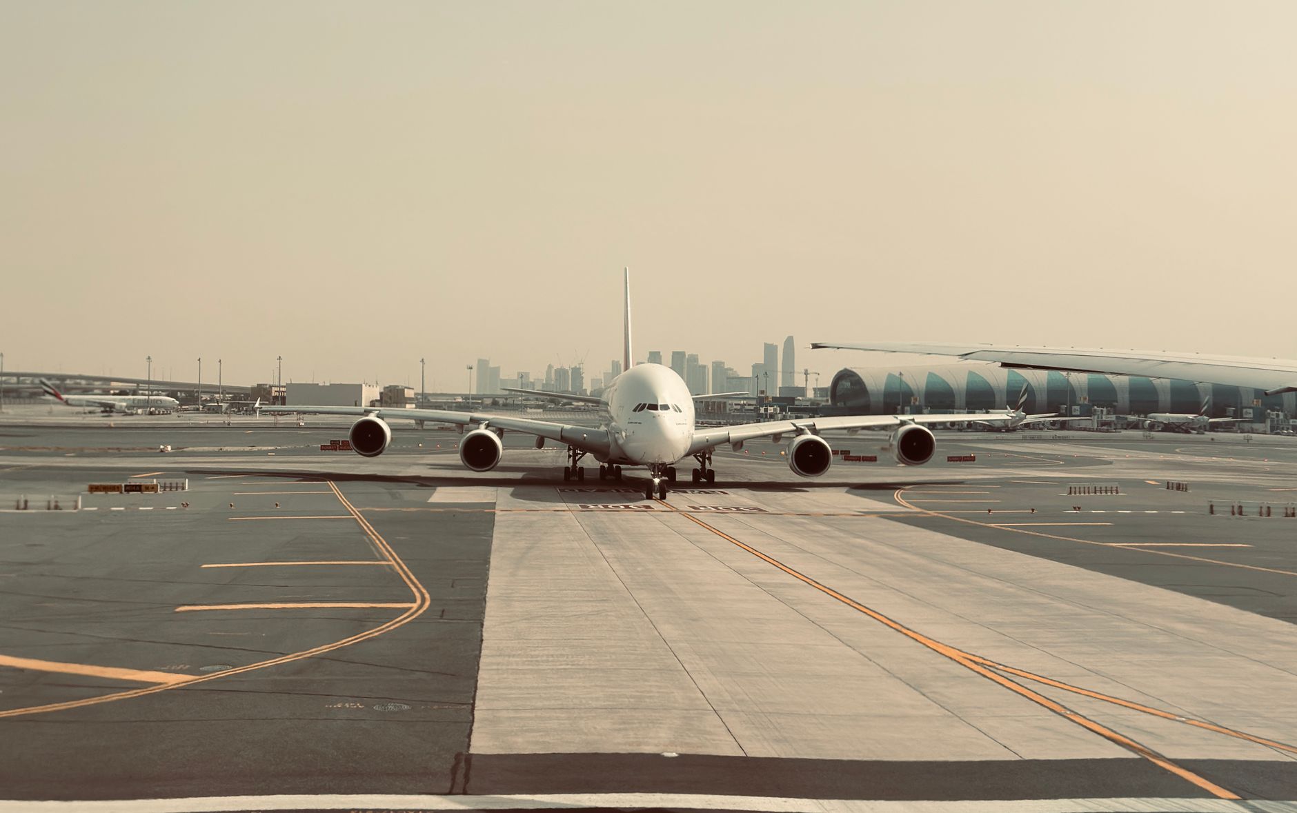An aircraft on the tarmac at Dubai International with the city skyline behind