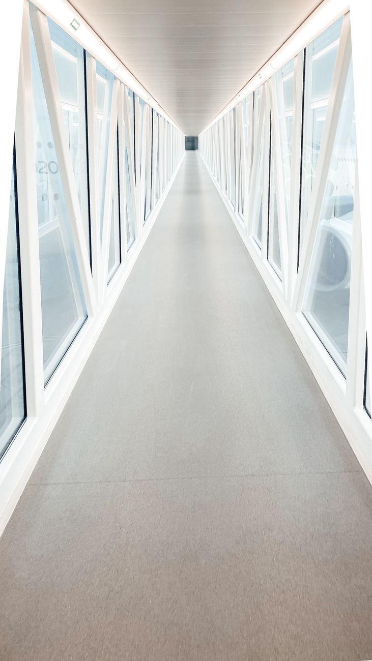 A long glass-paneled walkway inside Dubai International airport
